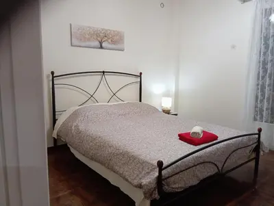 a bedroom with a bed with a red plate on it at Room Z for two 5' from metro in Athens
