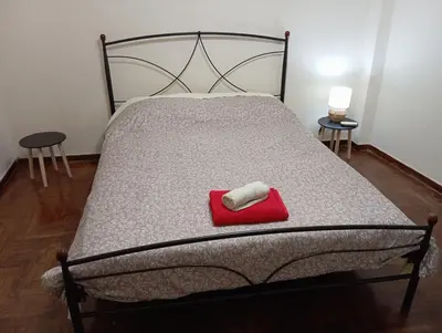a bed with a red towel on top of it at Room Z for two 5' from metro in Athens