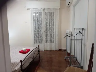 a bedroom with a bed with a red hat on it at Room Z for two 5' from metro in Athens