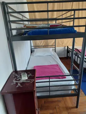 two bunk beds in a room with a table at SHARED ROOMS NEAR ACROPOLIS & MONASTIRAKi area in Athens