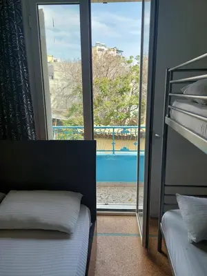 a bedroom with a bunk bed and a view of a pool at SHARED ROOMS NEAR ACROPOLIS & MONASTIRAKi area in Athens