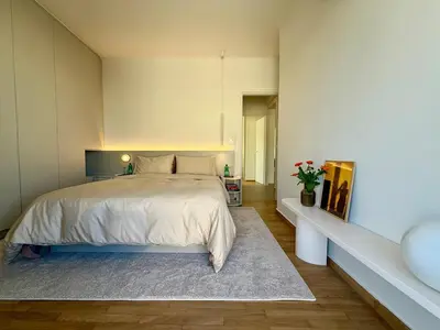 a bedroom with a large bed with a rug at Sunny Downtown Glyfada Penthouse in Athens