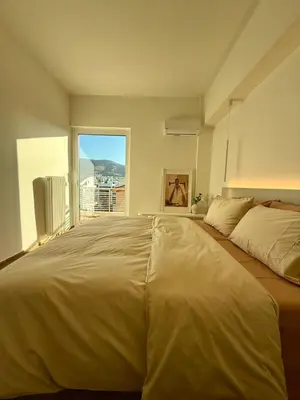 a large bed in a bedroom with a large window at Sunny Downtown Glyfada Penthouse in Athens