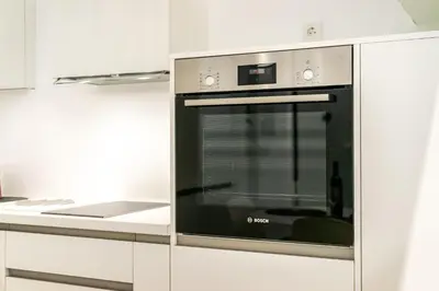 a stainless steel oven in a white kitchen at Downtown Properties Loft 2 in Athens