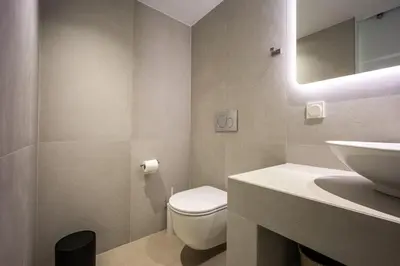 a bathroom with a white toilet and a sink at Downtown Properties Loft 2 in Athens