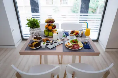a breakfast table with breakfast foods and orange juice at Piraeus Port Hotel in Piraeus
