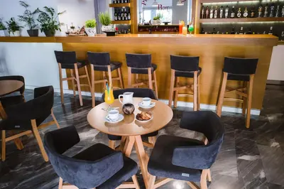 a table and chairs in front of a bar at Piraeus Port Hotel in Piraeus