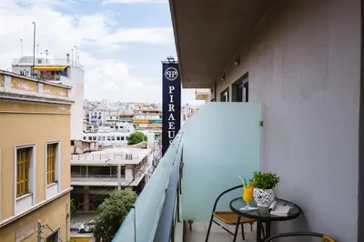 a balcony with a table and a view of a city at Piraeus Port Hotel in Piraeus