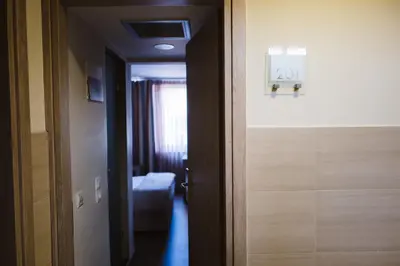 a hallway with a door to a room with a sign at Piraeus Port Hotel in Piraeus