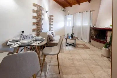 a dining room with a table and chairs and a fireplace at Fantasea Porto Rafti on the sea 15 minutes from the airport in Porto Rafti