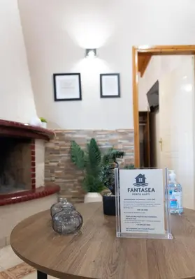 a table with a sign in a room with a fireplace at Fantasea Porto Rafti on the sea 15 minutes from the airport in Porto Rafti