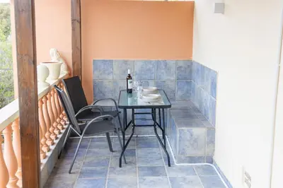 a table and chairs on a balcony with blue tiles at Fantasea Porto Rafti on the sea 15 minutes from the airport in Porto Rafti