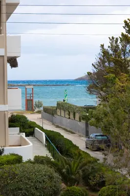 a car parked on a sidewalk next to the ocean at Fantasea Porto Rafti on the sea 15 minutes from the airport in Porto Rafti