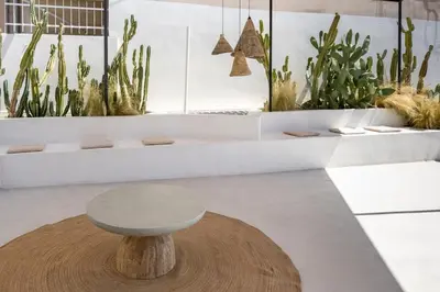 a table and stool in a room with plants at The Rooftop in Athens