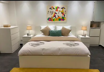 a bedroom with a large white bed with two lamps at Freddy enjoy kolonaki in Athens