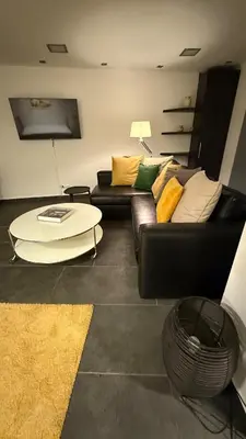 a living room with a black couch and a table at Freddy enjoy kolonaki in Athens