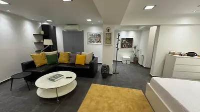 a living room with a black couch and a table at Freddy enjoy kolonaki in Athens