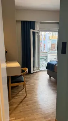 a room with a bed and a desk and a window at Acropolis luxury home by Cleo in Athens