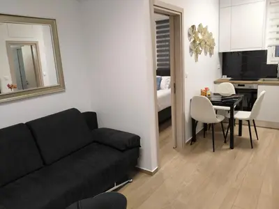 a living room with a black couch and a table at Cozy 1-Bedroom Flat in the Heart of Athens by ΜΡS in Athens
