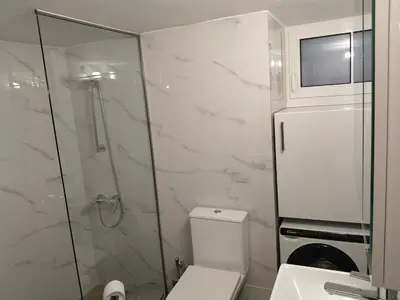 a bathroom with a toilet and a glass shower at Cozy 1-Bedroom Flat in the Heart of Athens by ΜΡS in Athens