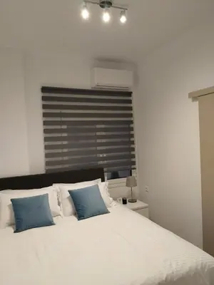 a bedroom with a large white bed with blue pillows at Cozy 1-Bedroom Flat in the Heart of Athens by ΜΡS in Athens