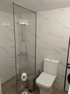 a bathroom with a toilet and a glass shower at Cozy 1-Bedroom Flat in the Heart of Athens by ΜΡS in Athens
