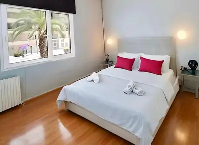 a bedroom with a large white bed with red pillows at Panathenaic Athens Center Apartment in Athens