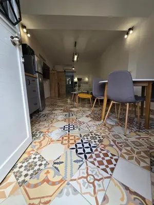 a room with a tile floor with chairs and a table at Kiki's comfort stay in West Athens in Athens