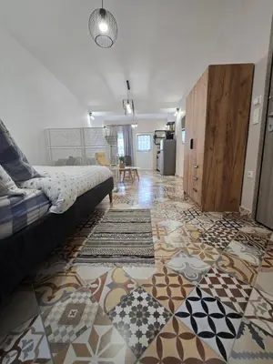 a bedroom with a bed and a floor with a rug at Kiki's comfort stay in West Athens in Athens