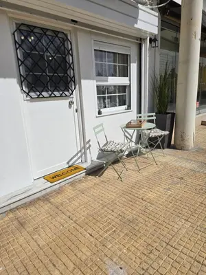 a patio with two chairs and a table in front of a door at Kiki's comfort stay in West Athens in Athens
