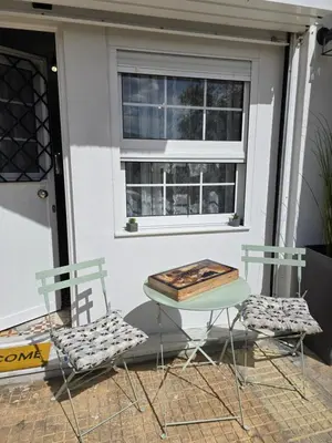 two chairs and a table in front of a window at Kiki's comfort stay in West Athens in Athens