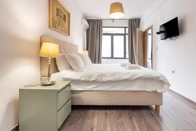a bedroom with a bed and a lamp on a night stand at Industrial-Style Apt in Psyrri, Walk to Acropolis in Athens