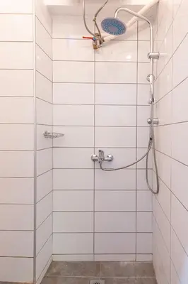 a bathroom with a shower with white tiles at Industrial-Style Apt in Psyrri, Walk to Acropolis in Athens