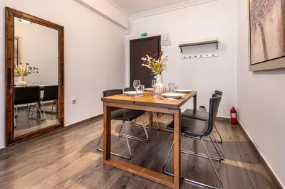 a dining room with a table with chairs and a mirror at Industrial-Style Apt in Psyrri, Walk to Acropolis in Athens