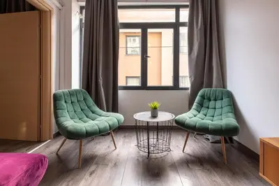 two green chairs and a table in a room at Industrial-Style Apt in Psyrri, Walk to Acropolis in Athens