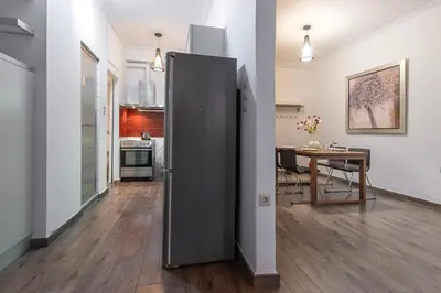 a large refrigerator in a kitchen with a table at Industrial-Style Apt in Psyrri, Walk to Acropolis in Athens