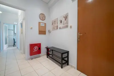 a hallway with a table and a clock on a wall at Spacious 3-Bedroom Apartment in Neos Kosmos by ΜΡS in Athens