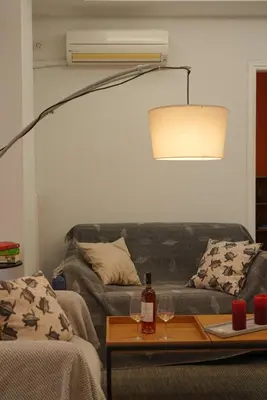 a living room with a couch and a table with a lamp at Summer Vacation Home in Vouliagmeni for 4 by Filos Inc in Athens