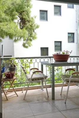 a patio with a table and chairs on a balcony at Summer Vacation Home in Vouliagmeni for 4 by Filos Inc in Athens