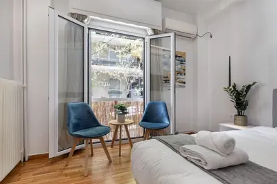 a bedroom with two blue chairs and a window at Viora - Stunning Deluxe Studio in Athens in Athens