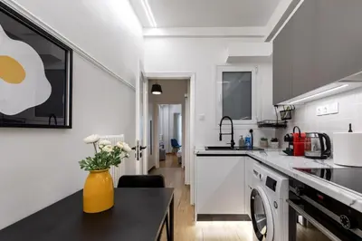 a white kitchen with a vase of flowers on a counter at Viora - Stunning Deluxe Studio in Athens in Athens