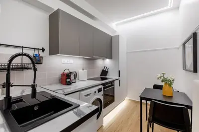 a white kitchen with a sink and a stove at Viora - Stunning Deluxe Studio in Athens in Athens