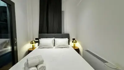 a small bedroom with a bed with towels on it at Downtown Modern Studio in Athens
