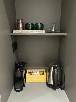 a kitchen shelf with a coffee maker and a tea kettle at Downtown Modern Studio in Athens