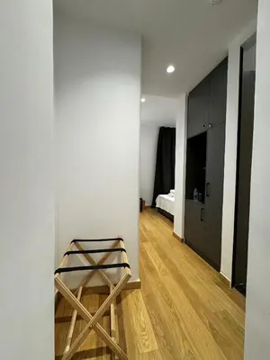 a room with a white wall and a wooden stool at Downtown Modern Studio in Athens