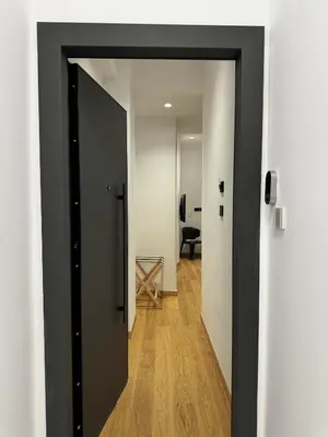 a black door leading into a hallway with a chair at Downtown Modern Studio in Athens