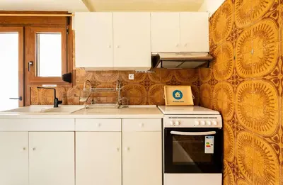a kitchen with white cabinets and a stove top oven at Athenian Living in the Heart of Koukaki in Athens