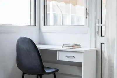 a desk with a chair next to a window at Athenian Living in the Heart of Koukaki in Athens