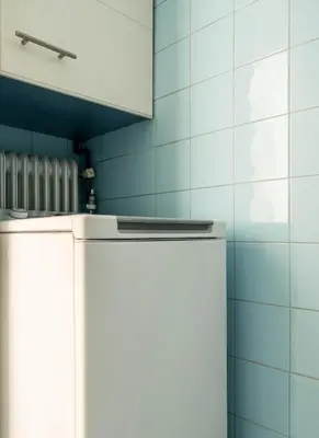 a white refrigerator in a kitchen with blue tiles at Athenian Living in the Heart of Koukaki in Athens