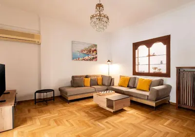 a living room with a couch and a table at Athenian Living in the Heart of Koukaki in Athens